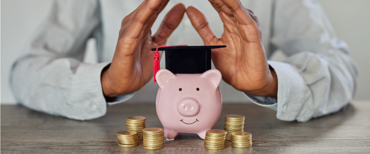 Piggy bank with a graduation cap and coins around it
