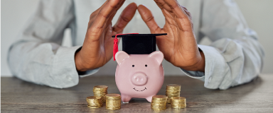 Piggy bank with a graduation cap and coins around it