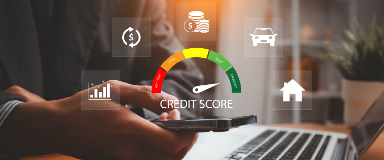 Man on his phone and computer with a gauge indicating a good credit score.