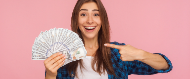 Woman holding a fan of money and smiling