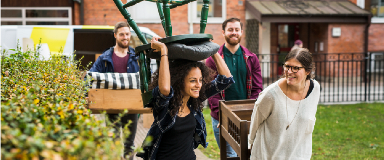 A group of friends carrying furniture together