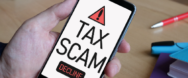 Cell phone with the words "Tax Scam" on the screen, with the opportunity to decline the call.