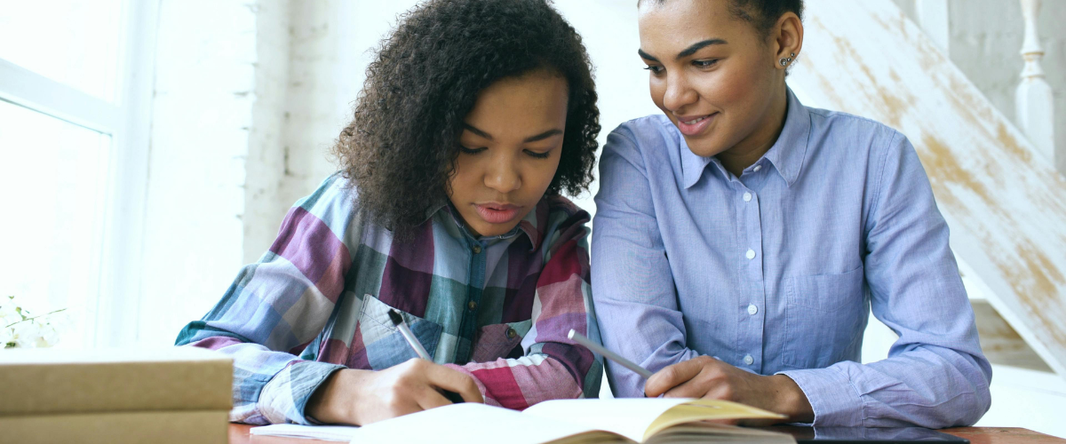 Mom and child looking at a book together, learning.