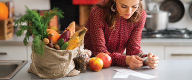 Woman looking at receipt after buying groceries.