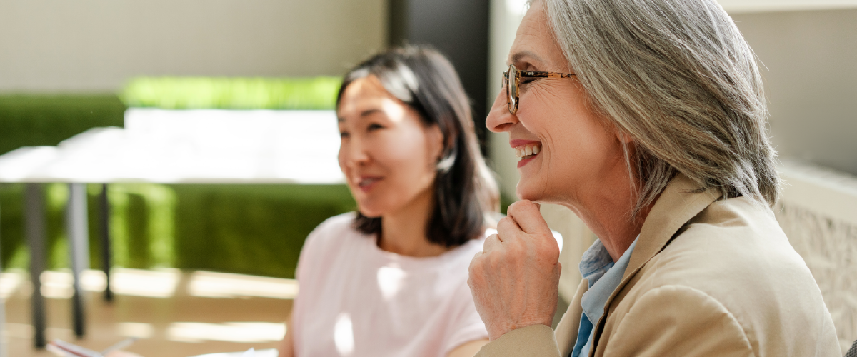 Two women sitting and smiling at a finance meeting
