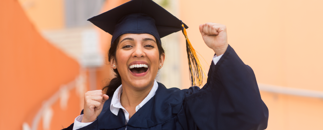 Young woman cheering in graduation cap and gown