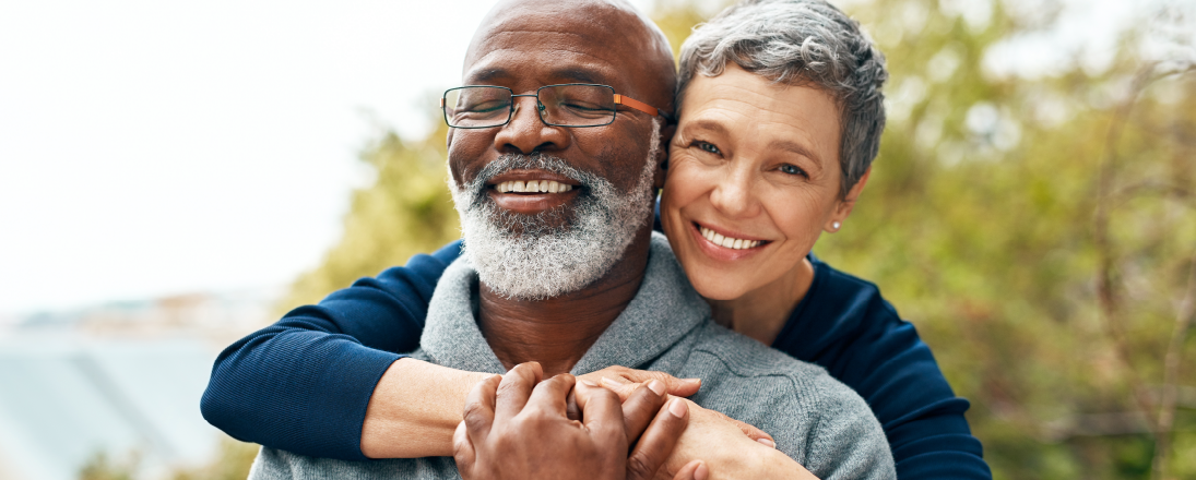 An older couple smiling and embracing