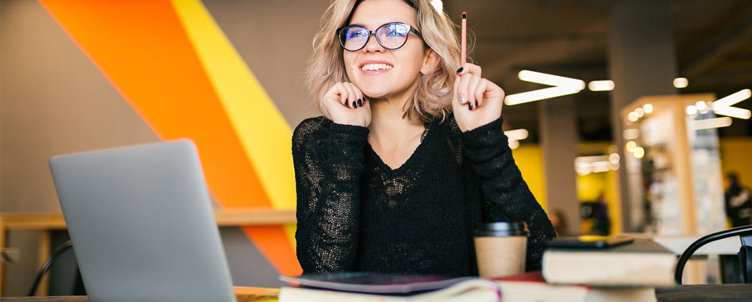 Young business woman with glasses and a pencil working