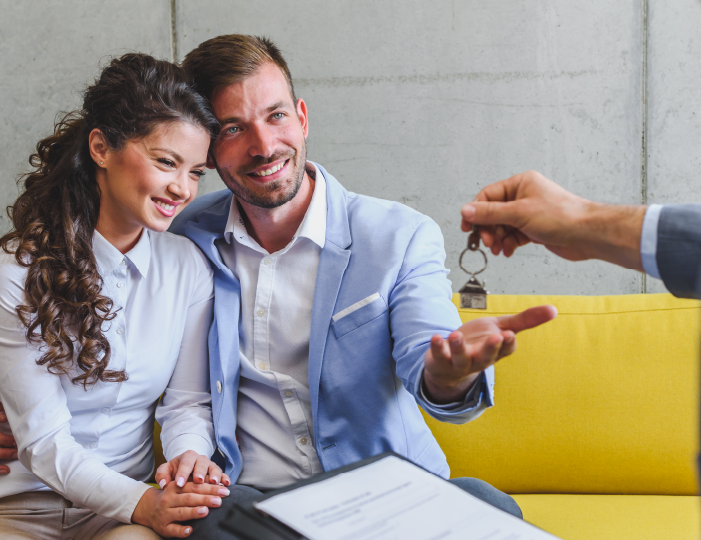 Couple meeting with mortgage lender, getting the keys to their new home