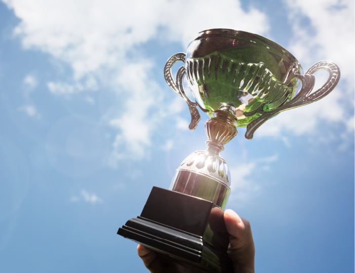Hand holding trophy to the sky