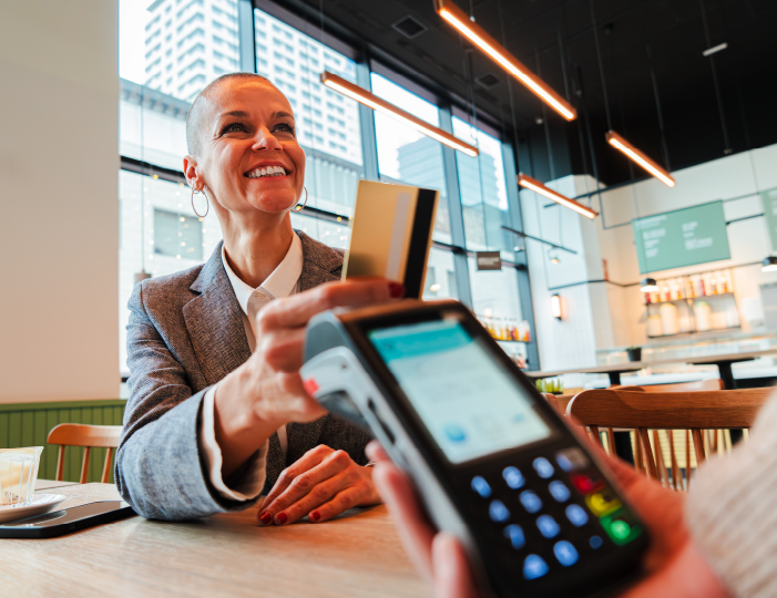 Woman using debit card to pay at a restaurant