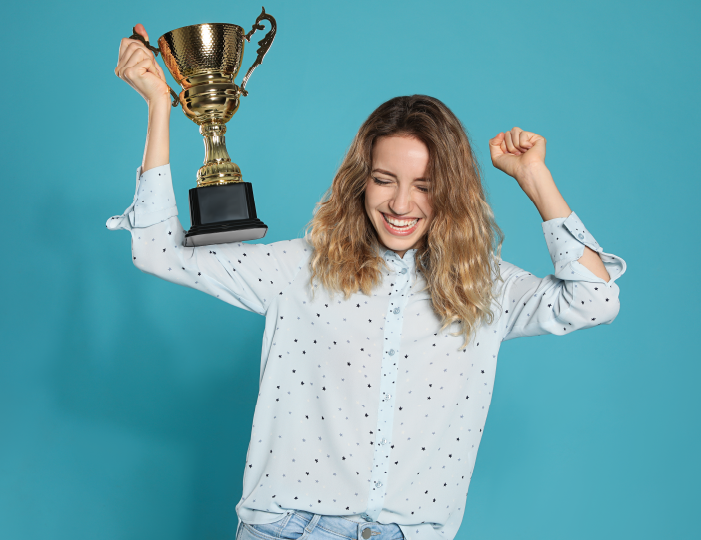 Woman cheering with trophy in hand